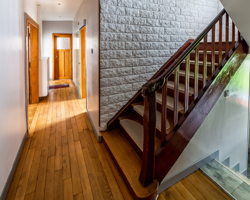 Maison individuelle, 3 chambres, 100 m² habitables - Escalier bois vers le 1er étage et marches vers le sous-sol et porte donnant au jardin.